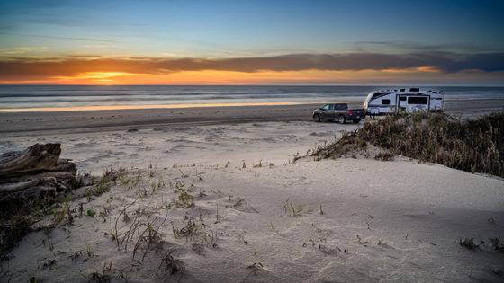 Photo of a truck and trailer camping on a Texas beach