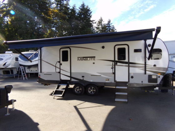 Photo of a 2023 Forest River Rockwood Mini Lite with its awning open. White with grey and black accents.