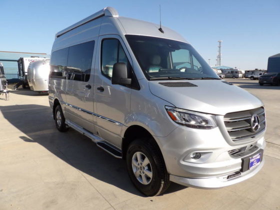 Photo of a silver 2024 Airstream Interstate in an RV dealer lot 
