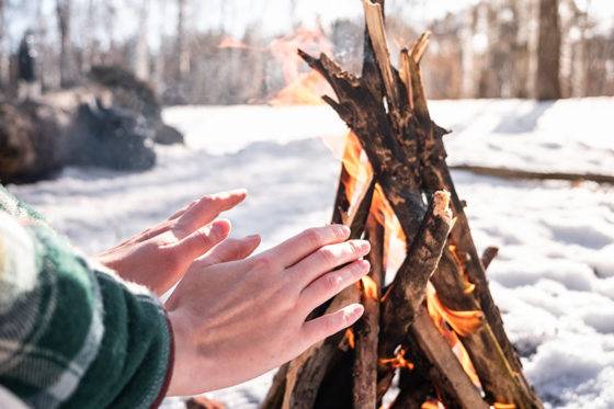 Warming hands at a winter campfire in the snow