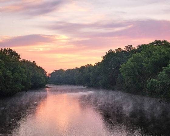 Photo of a pink and purple sunrise over the White River in Indiana