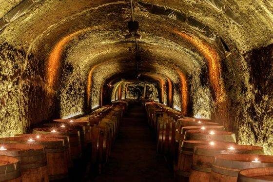 Photo of candlelit barrels in Del Dotto Historic Winery Caves in Napa Valley. St. Helena, California