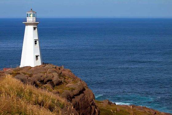 A photo of the Cape Spear lighthouse on a jutting cliff overlooking the Atlantic Ocean, the most easterly point in North America.