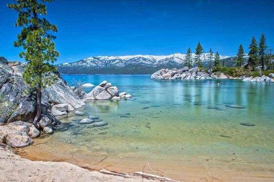 Photo of the view of Lake Tahoe at D.L. Bliss State Park with snowy mountains in the distance